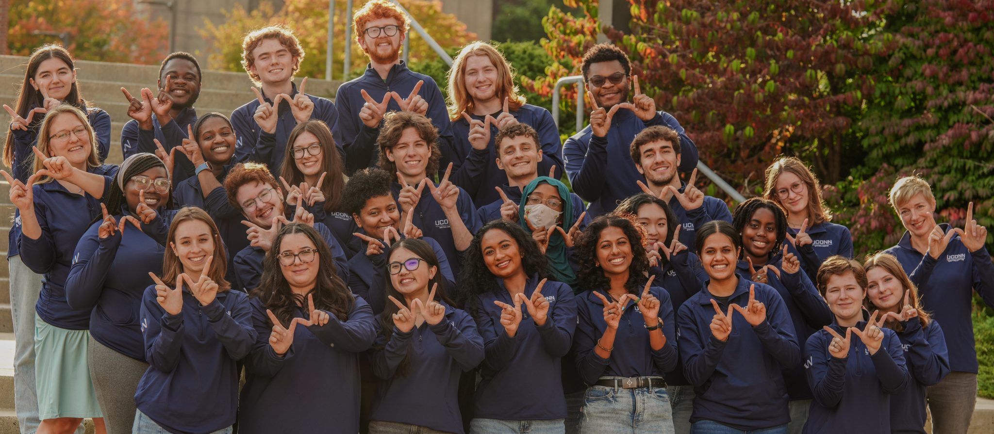 Students in a group making a W with their fingers 